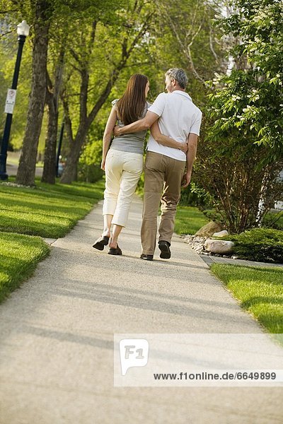 Rear View Of A Couple Walking On Pathway