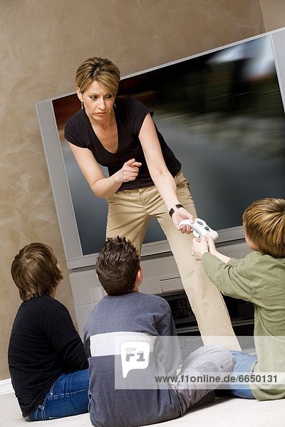 Woman Stopping Boys From Playing Video Game