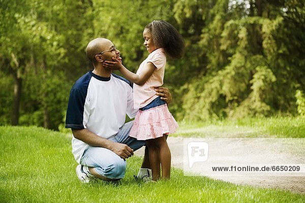 Side View Of Father With Daughter In Park