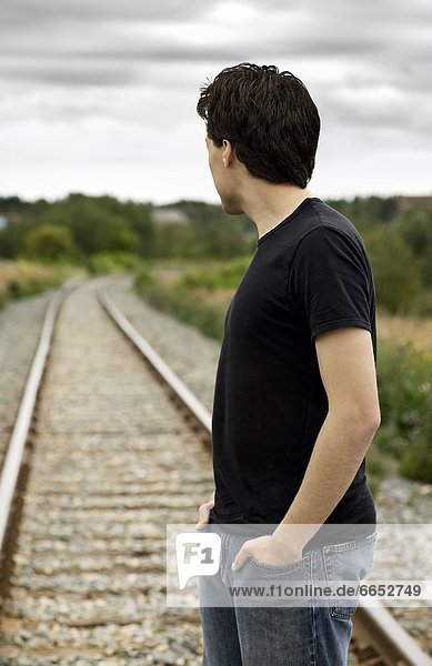 Side View Of A Man Standing On Train Track