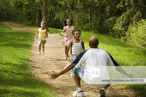 Three Girls Running To Their Dad