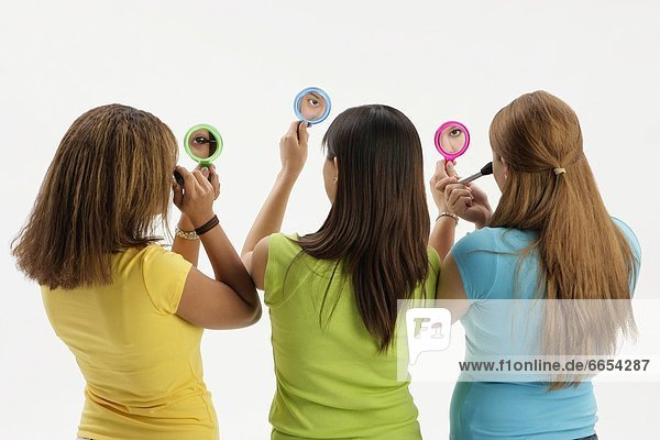Three Teen Girls With Compact Mirrors