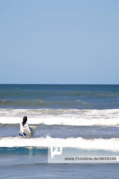 Frau  nehmen  Surfboard  Meer