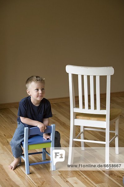 Little Boy Sitting On A Chair