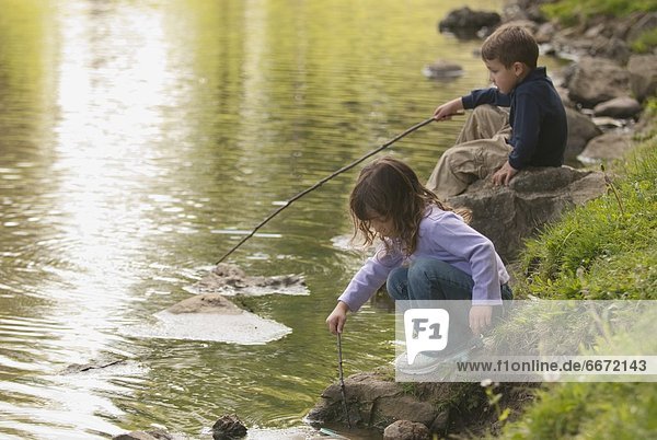 Two Kids Playing In A Pond