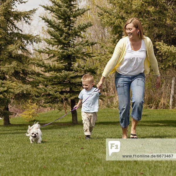 Mother And Son Running With Dog
