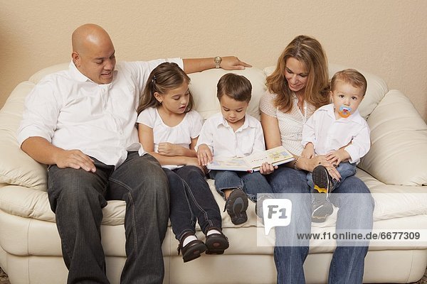 Family Looking At A Book Together