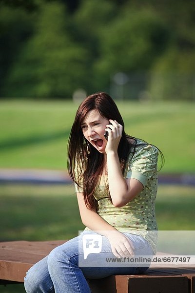 A Girl Talking On Her Cell Phone With A Surprised Look