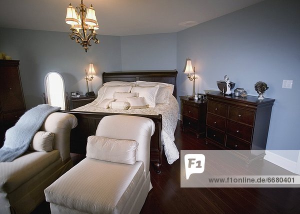 A Bedroom With Chaise Lounge Chairs At The Foot Of The Bed