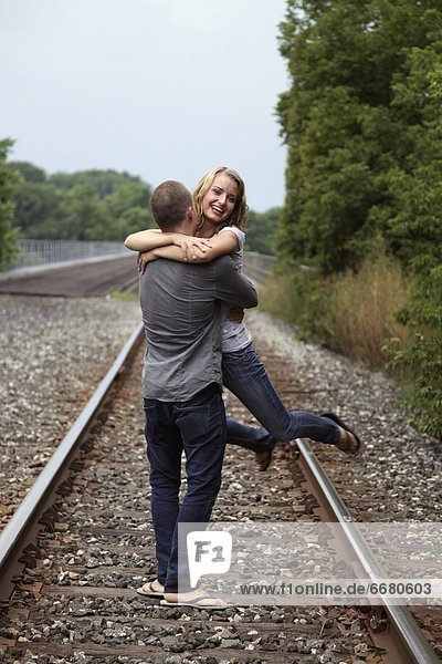 A Couple Hugging On The Train Tracks