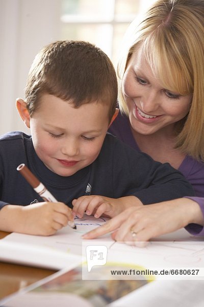 A Mother Doing Workbook Activities With Her Son