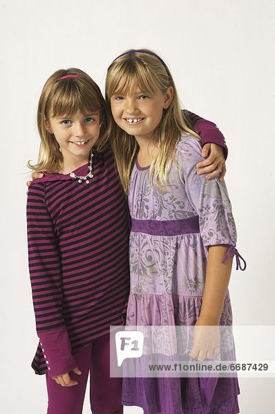 Two Girls Wearing Purple With Their Arms Around Each Other