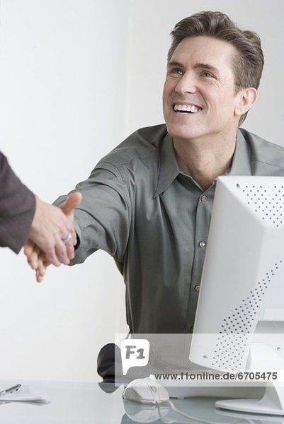 Businessman at desk shaking hands