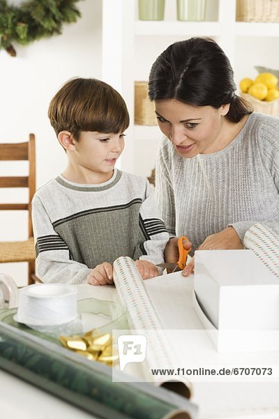 Mother and son wrapping Christmas gifts