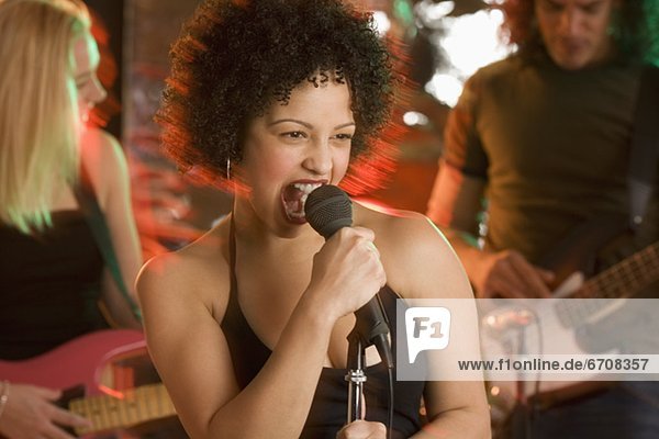 Woman singing with a band