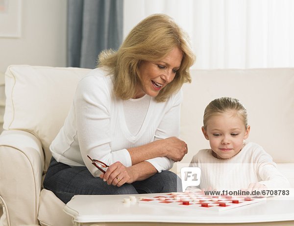 Grandmother and young granddaughter playing checkers