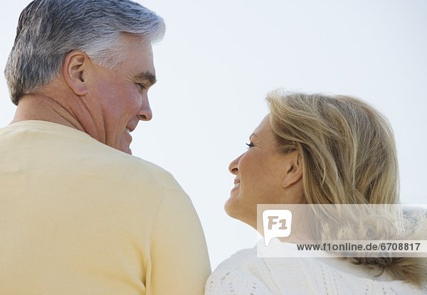 Senior couple smiling and looking at each other outdoors