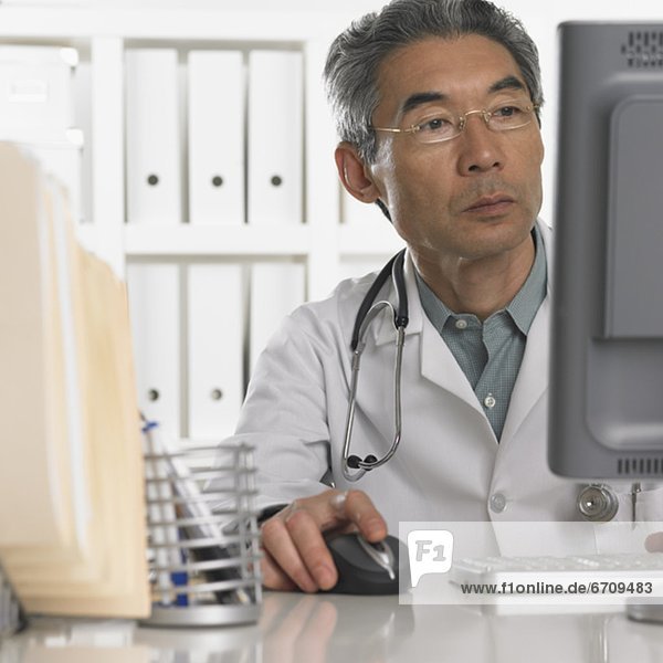 Senior male doctor using computer