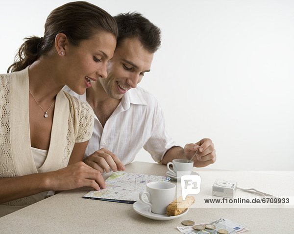 Couple looking at map and having coffee