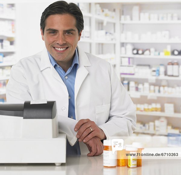 Male pharmacist at counter with medication