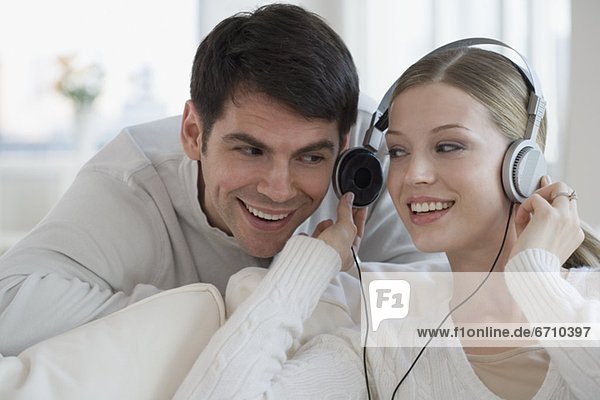 Woman sharing headphones with husband