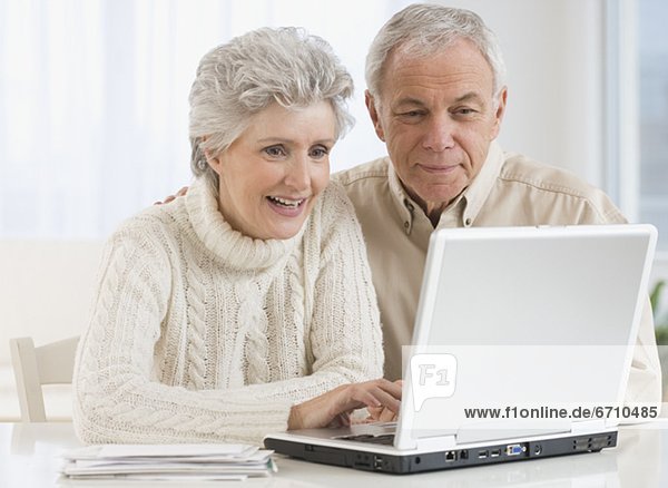 Senior couple looking at laptop