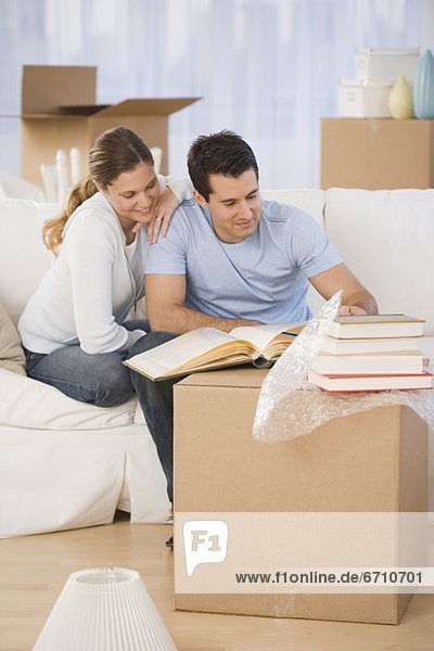 Couple unpacking books in new house