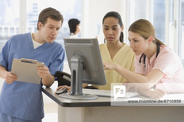 Doctors looking at computer in hospital
