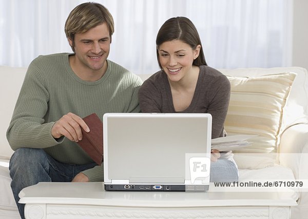Couple paying bills on laptop