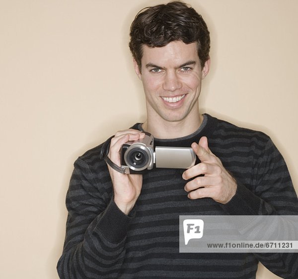 Portrait of man holding video camera