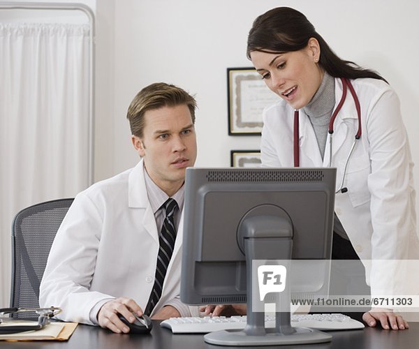 Doctors looking at computer in office