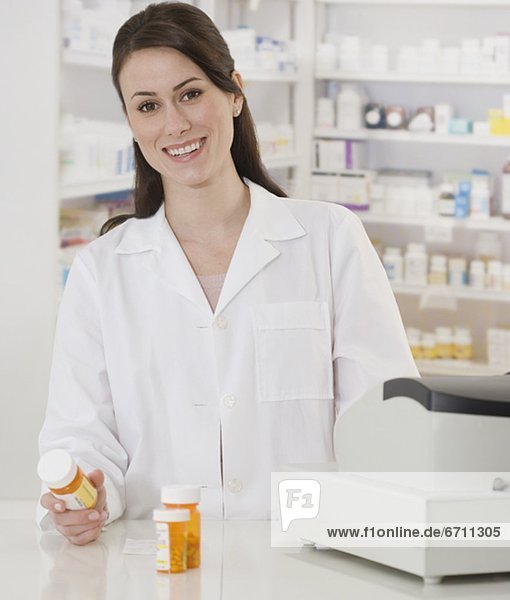 Portrait of female pharmacist holding medication