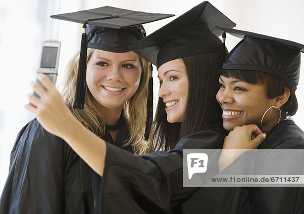 Multi-ethnic female graduates taking own photograph