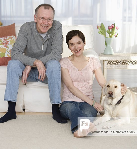 Portrait of couple with dog in livingroom