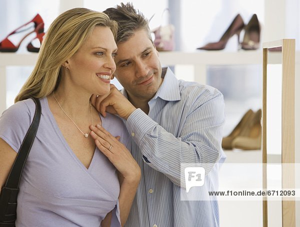 Couple looking at necklace in boutique