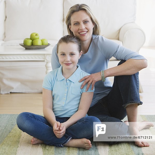 Mother and daughter sitting on floor