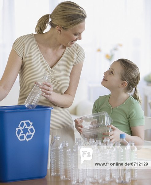 Mother and daughter filling recycle bin