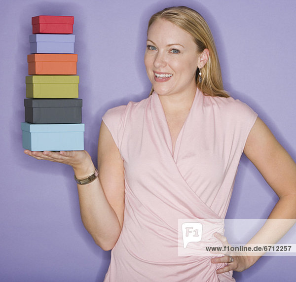Woman holding stack of gift boxes