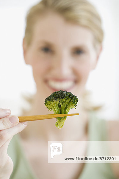 Frau  Eßstäbchen  halten  Broccoli