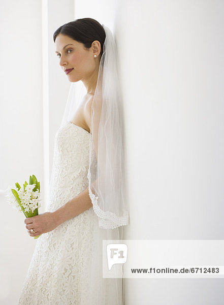 Bride leaning on wall
