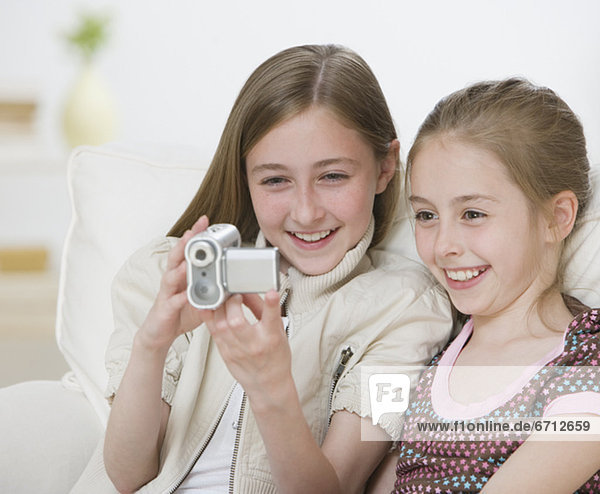Two sisters looking video camera