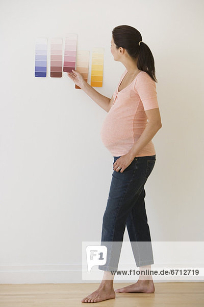 Pregnant woman looking at paint swatches