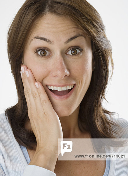 Woman looking surprised with hand on cheek
