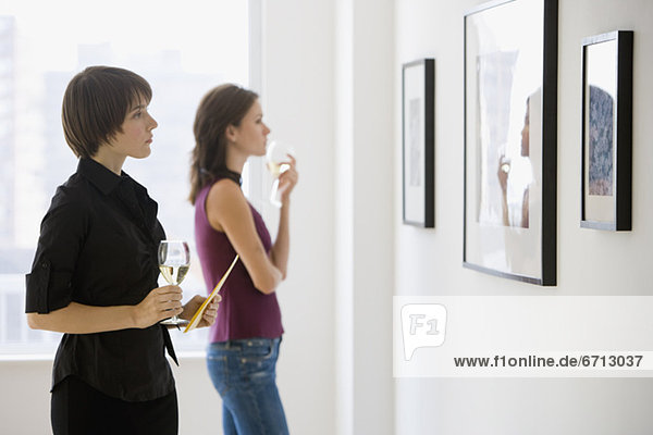 Two women looking at artwork in gallery