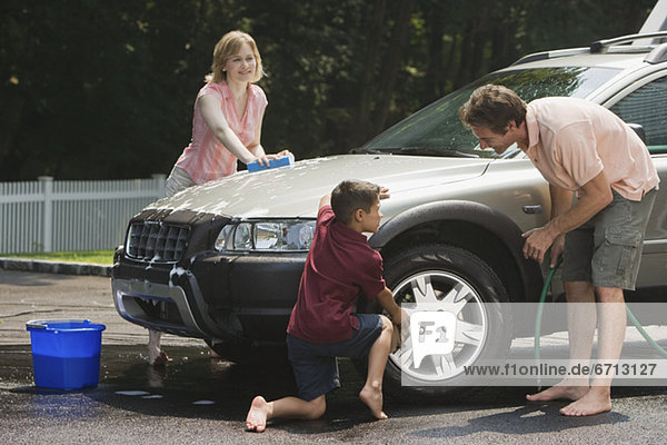 Family washing car in driveway