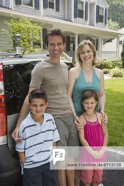 Family standing behind car