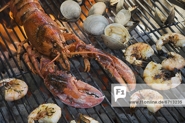 Lobster  shrimp and clams cooking on grill