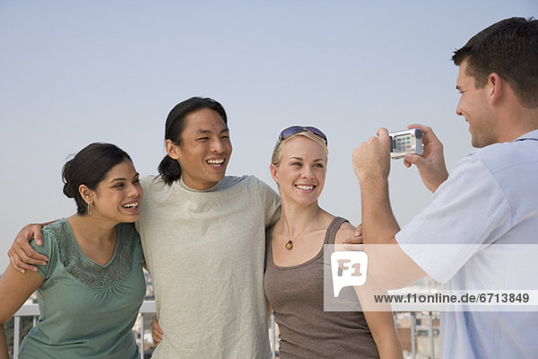 Multi-ethnic friends having photograph taken