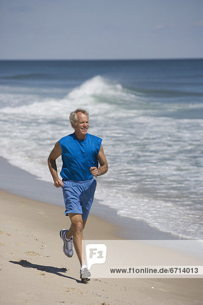 älterer Mann joggen am Strand