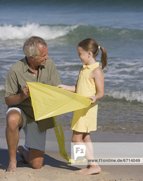 Father and daughter with kite at beach